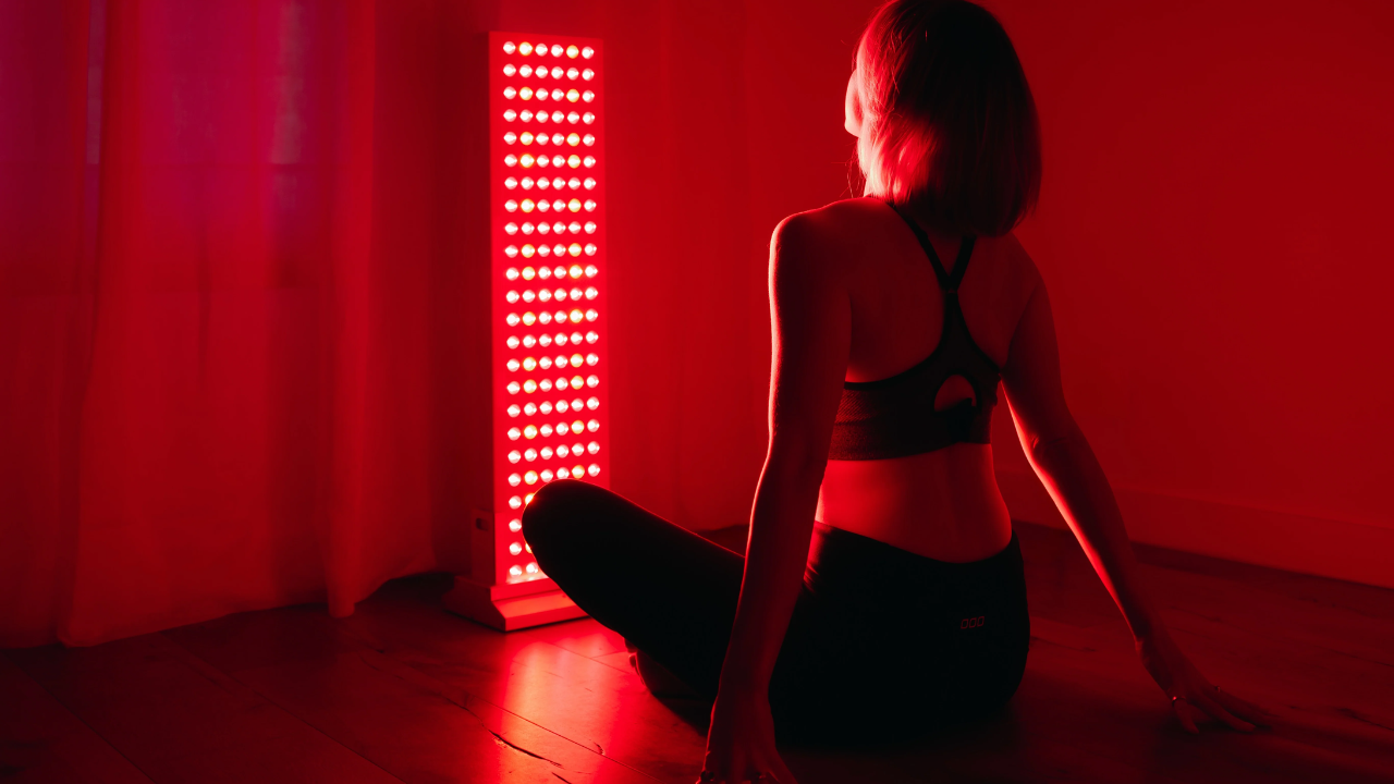 Athlete using full-body red light therapy LED panels for recovery